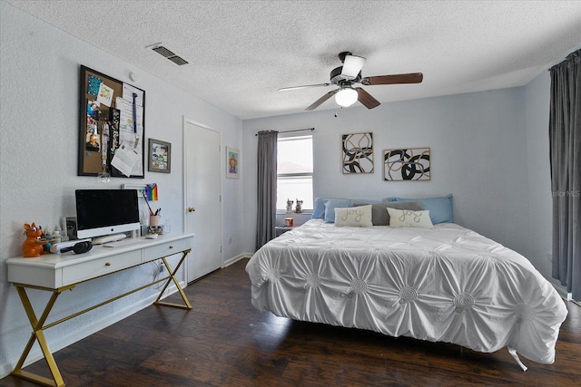 bedroom featuring dark wood-type flooring, ceiling fan, and a textured ceiling