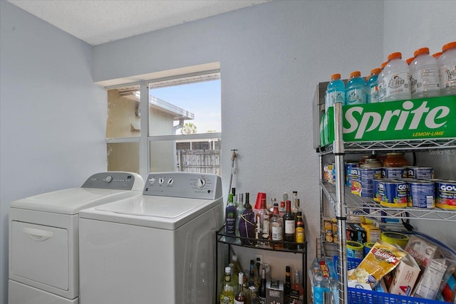 clothes washing area featuring washing machine and dryer and a textured ceiling