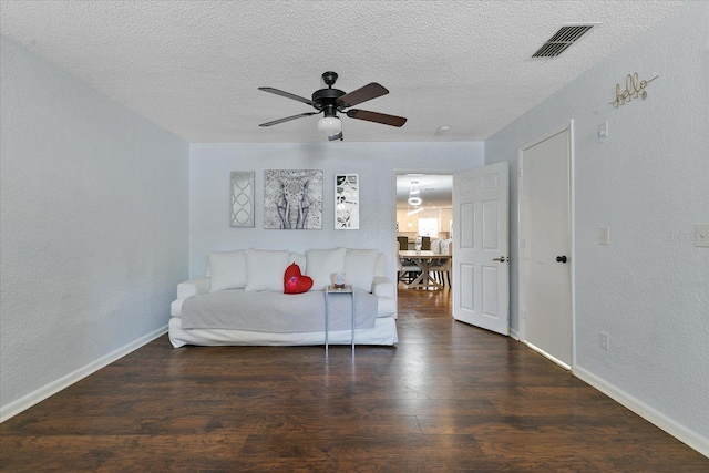 bedroom featuring ceiling fan, dark hardwood / wood-style flooring, and a textured ceiling