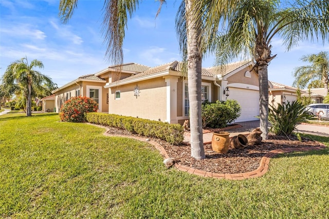 mediterranean / spanish-style home featuring a garage and a front lawn