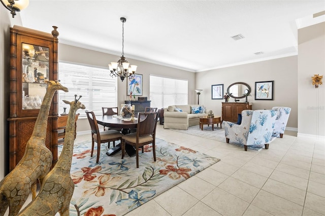 dining area with light tile patterned flooring, ornamental molding, and a notable chandelier