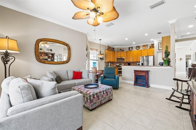 tiled living room with crown molding and ceiling fan