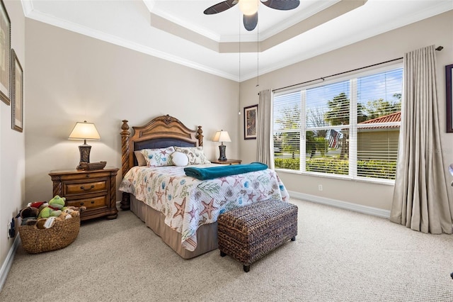 bedroom featuring ceiling fan, ornamental molding, a tray ceiling, and light carpet