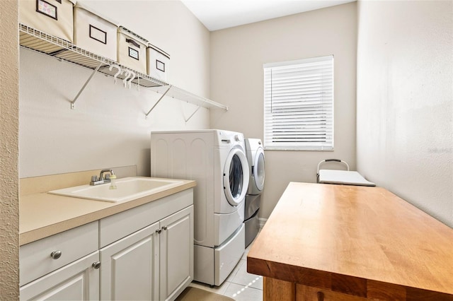 laundry area featuring cabinets, sink, washer and dryer, and light tile patterned floors