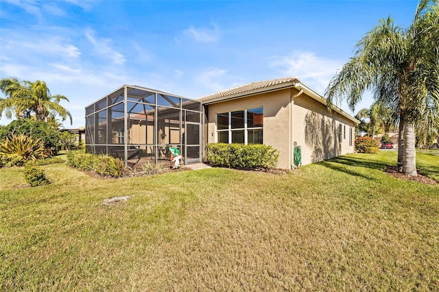 back of house featuring a lanai and a yard