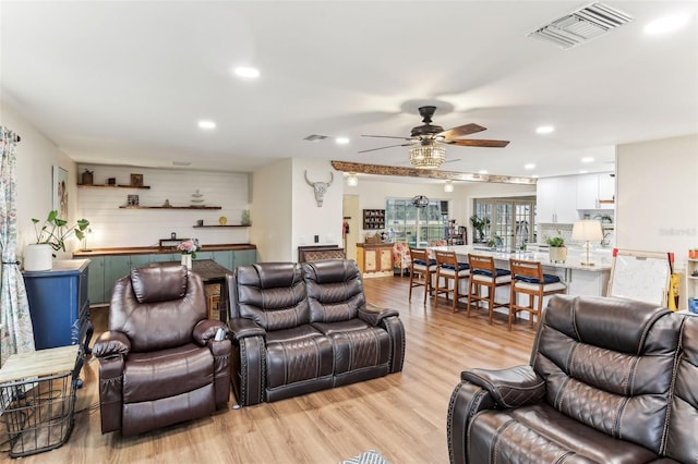 living room with ceiling fan and light wood-type flooring