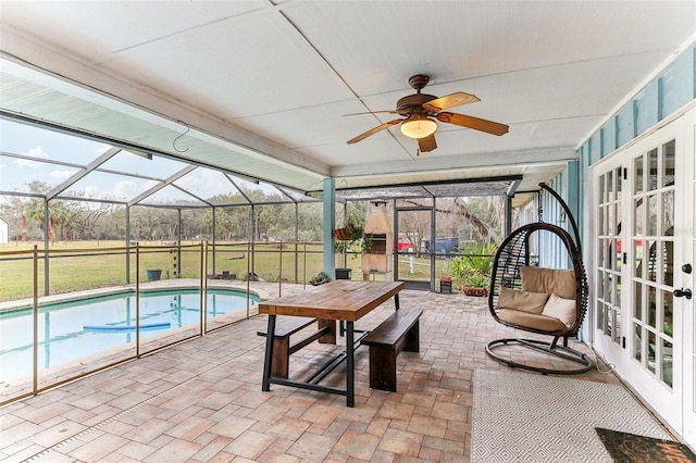 view of swimming pool featuring french doors, ceiling fan, a lanai, and a patio area