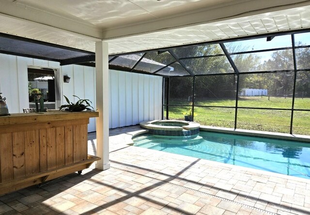 view of swimming pool with exterior bar, a patio area, an in ground hot tub, and glass enclosure