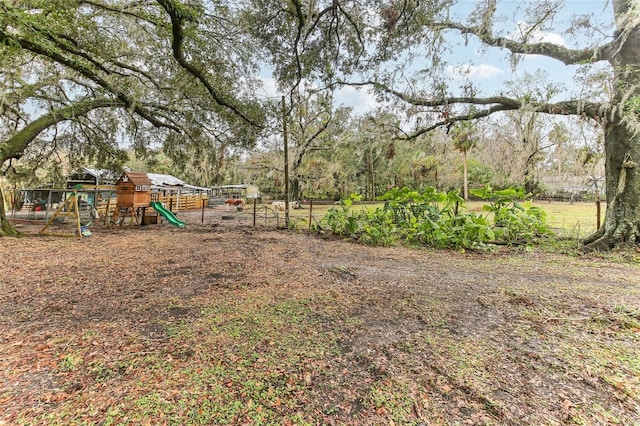 view of yard with fence and a playground