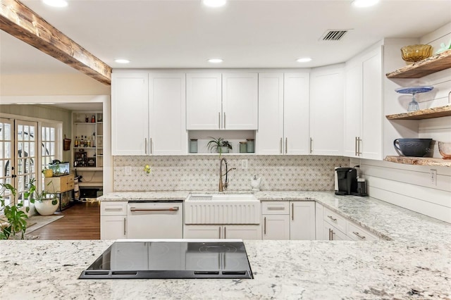 kitchen with white dishwasher, cooktop, visible vents, a sink, and open shelves