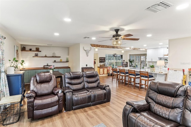 living room with a ceiling fan, recessed lighting, light wood-style floors, and visible vents