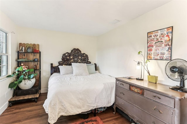 bedroom with baseboards, dark wood finished floors, and visible vents