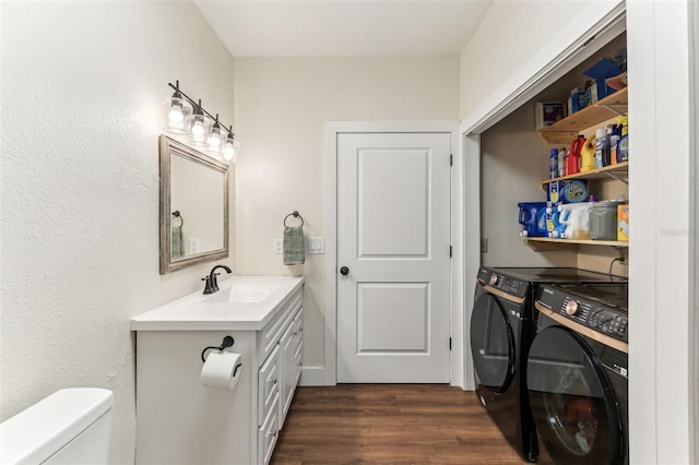 laundry room featuring laundry area, dark wood finished floors, independent washer and dryer, and a sink