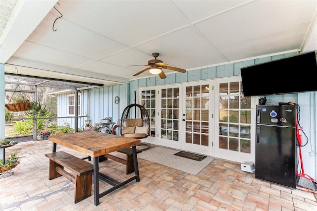 sunroom / solarium featuring outdoor dining area, french doors, and a ceiling fan