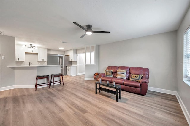 living room with light hardwood / wood-style floors and ceiling fan