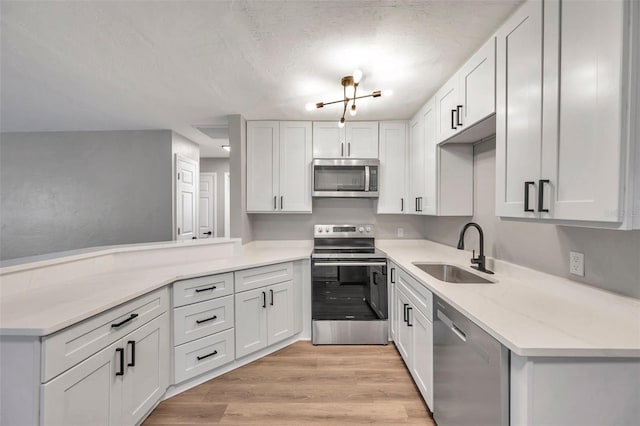 kitchen featuring light stone counters, sink, white cabinets, and stainless steel appliances