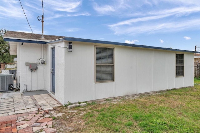 view of property exterior featuring a lawn and central air condition unit