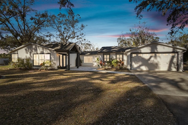 single story home featuring a garage and a yard