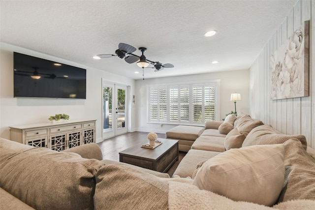 living room featuring hardwood / wood-style floors, a textured ceiling, french doors, and ceiling fan