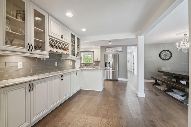 kitchen featuring sink, stainless steel fridge, light stone counters, white cabinets, and dark hardwood / wood-style flooring