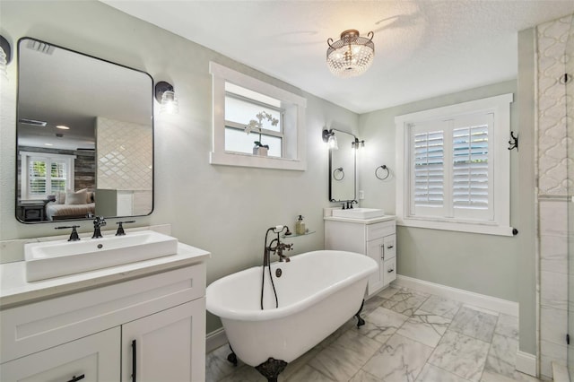 bathroom featuring vanity, a wealth of natural light, a textured ceiling, and a washtub