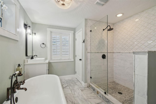 bathroom featuring plus walk in shower, vanity, and a textured ceiling