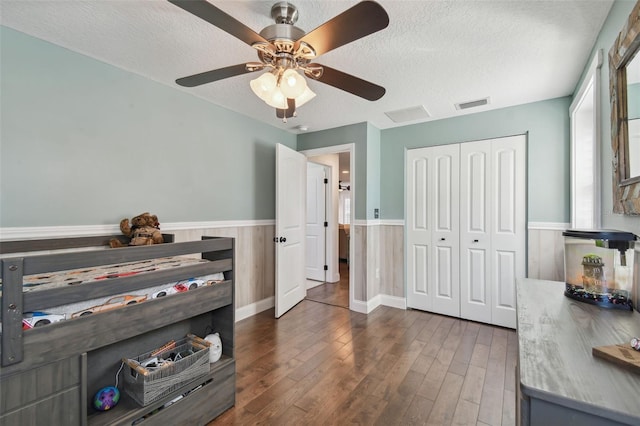 interior space featuring a textured ceiling, dark wood-type flooring, a closet, and ceiling fan