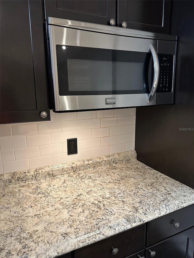 kitchen with light stone countertops and decorative backsplash