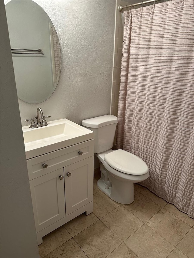 bathroom with tile patterned flooring, vanity, curtained shower, and toilet