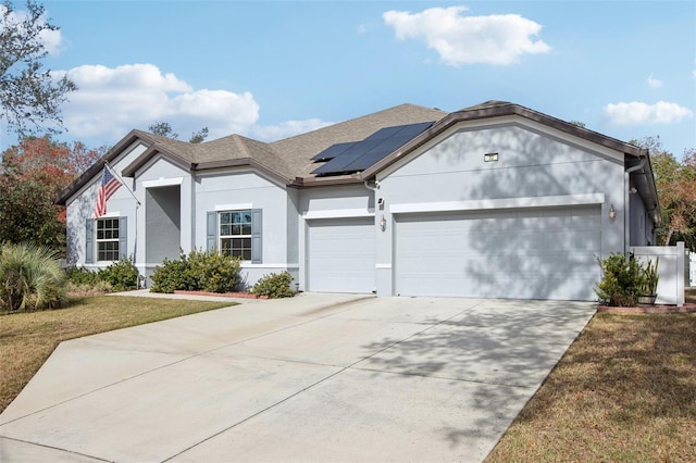 single story home featuring a garage, a front lawn, and solar panels