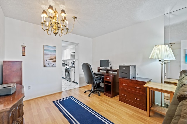 home office with light hardwood / wood-style flooring, a chandelier, and a textured ceiling