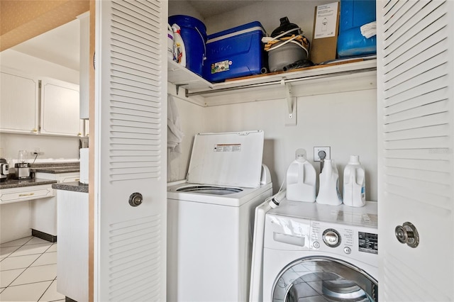 clothes washing area with light tile patterned floors and washing machine and dryer