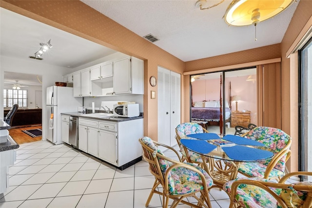 kitchen with sink, white cabinets, light tile patterned floors, ceiling fan, and white appliances