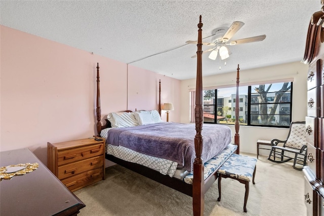 bedroom featuring ceiling fan, light carpet, and a textured ceiling