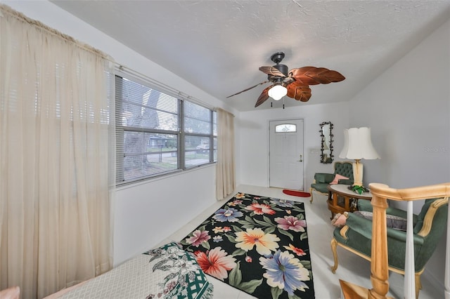 entrance foyer with ceiling fan and a textured ceiling