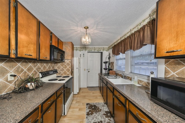 kitchen with sink, tasteful backsplash, light wood-type flooring, pendant lighting, and white appliances