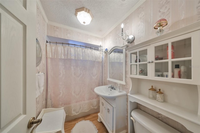 bathroom with hardwood / wood-style floors, vanity, ornamental molding, a textured ceiling, and toilet