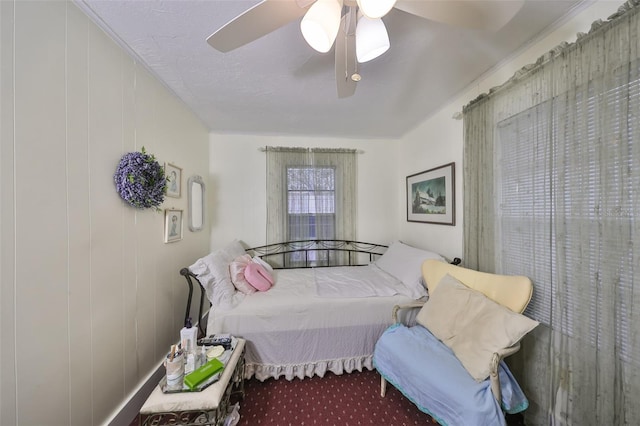 carpeted bedroom with ceiling fan and wood walls