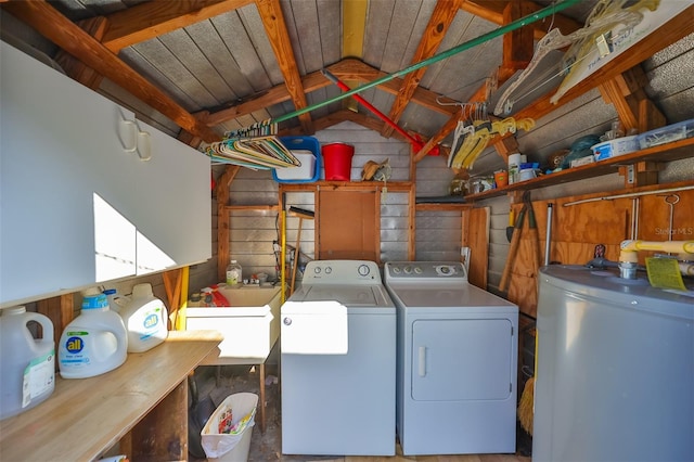 laundry area with washing machine and clothes dryer, sink, and water heater