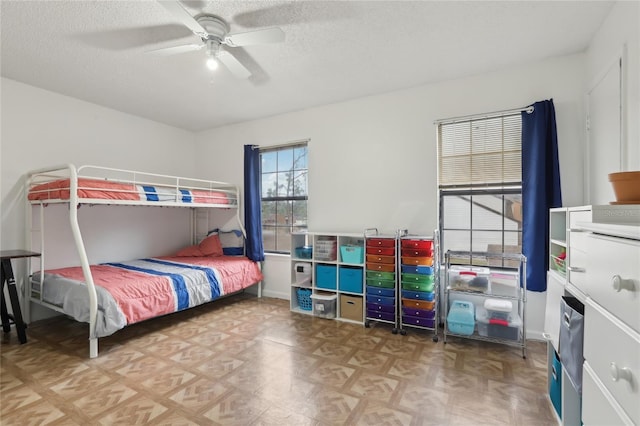 bedroom with parquet floors, ceiling fan, and a textured ceiling