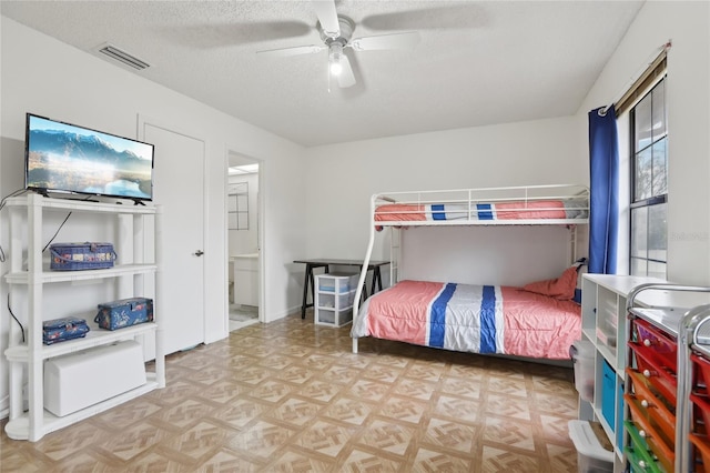 bedroom featuring ceiling fan, a textured ceiling, and light parquet floors