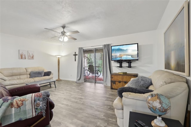 living area with ceiling fan, baseboards, and wood finished floors