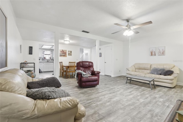 living room featuring ceiling fan and light hardwood / wood-style floors