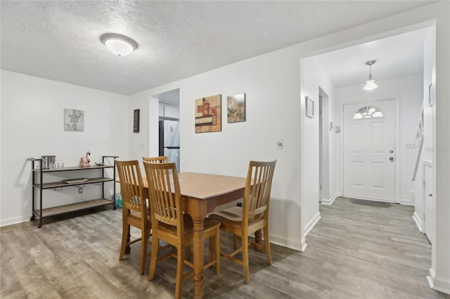 dining area featuring hardwood / wood-style flooring and a textured ceiling