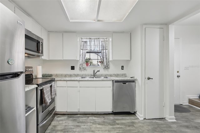 kitchen featuring stainless steel appliances, sink, and white cabinets