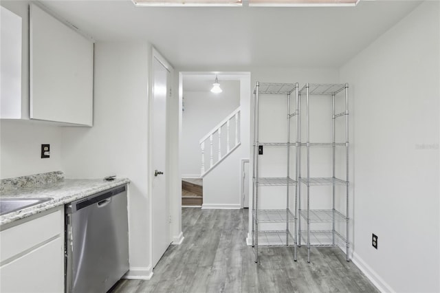 kitchen with white cabinetry, stainless steel dishwasher, and light hardwood / wood-style floors