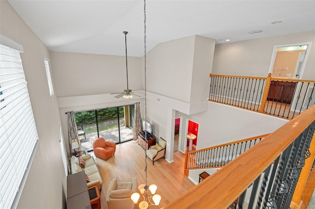 living room featuring ceiling fan, high vaulted ceiling, and light hardwood / wood-style floors