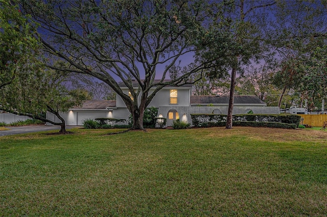 view of front of house with a garage and a yard