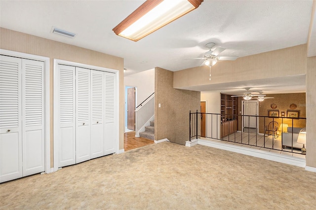 unfurnished living room with ceiling fan and carpet floors