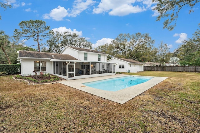 rear view of property with a fenced in pool, a sunroom, and a lawn